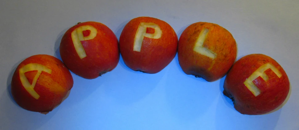 five apples with different letters spelled on them