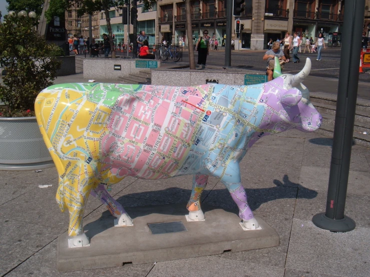 colorful cow statue standing next to lamp post