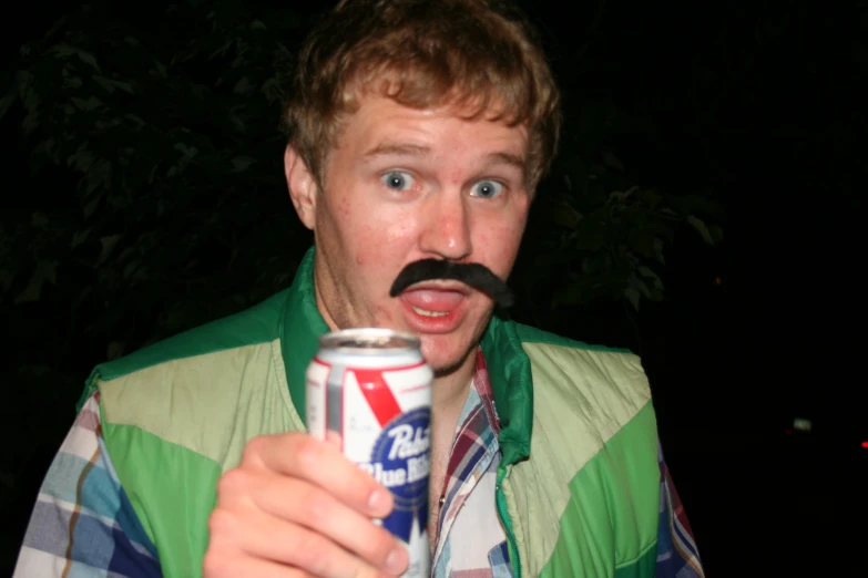 a man holding an open can with a mustache in his mouth