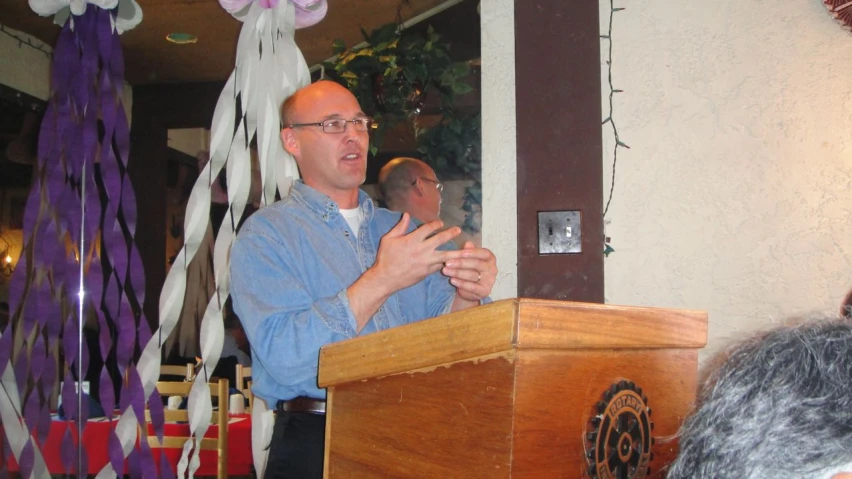 a man is making a speech at a podium