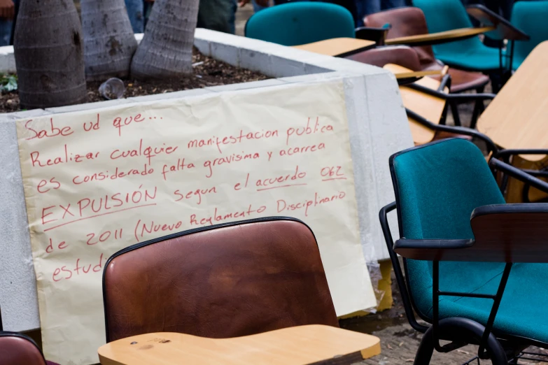 a sign and chairs set up near each other in a school classroom