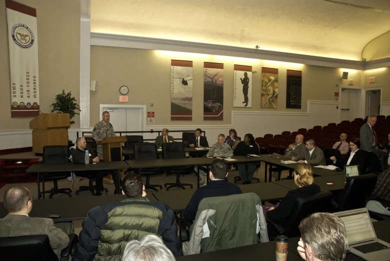 several people are sitting in chairs at the table