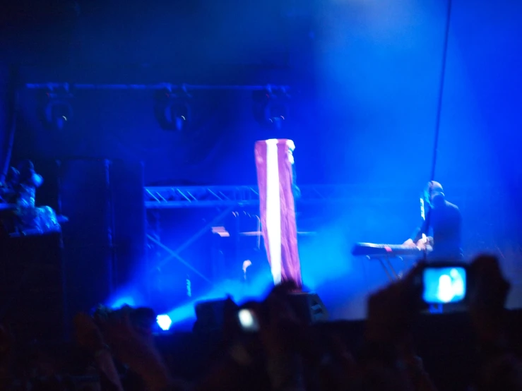 people standing in front of the camera watching a person on stage