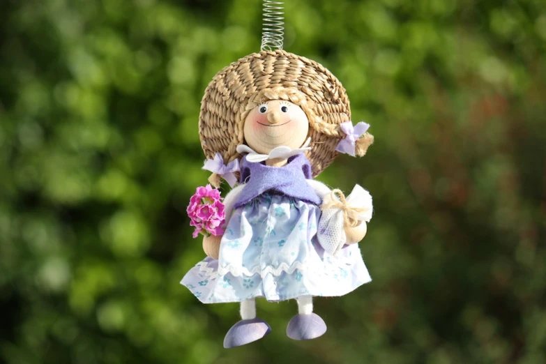 a wooden doll hanging from a wire on a string