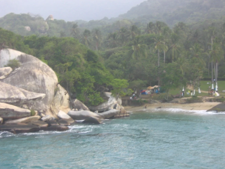 a beach view with several people near some rocks