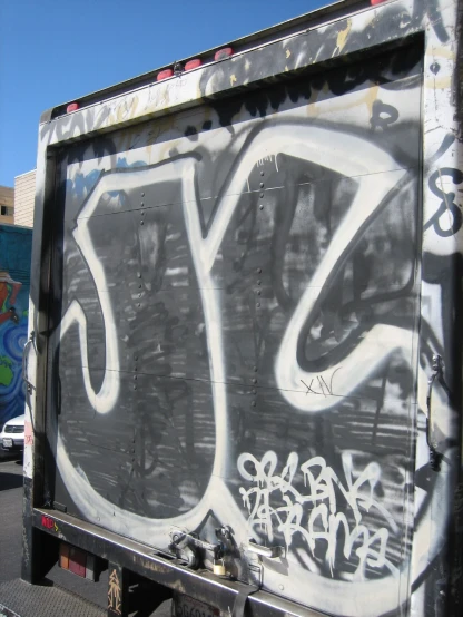 a graffiti covered truck driving past a building