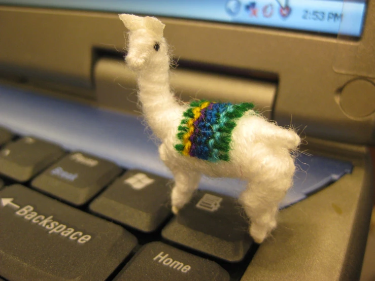 the needled animal is decorated in a rainbow sweater