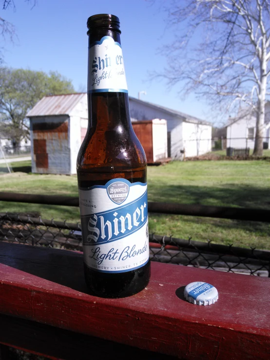 a close up of a bottle on a table with a building in the background