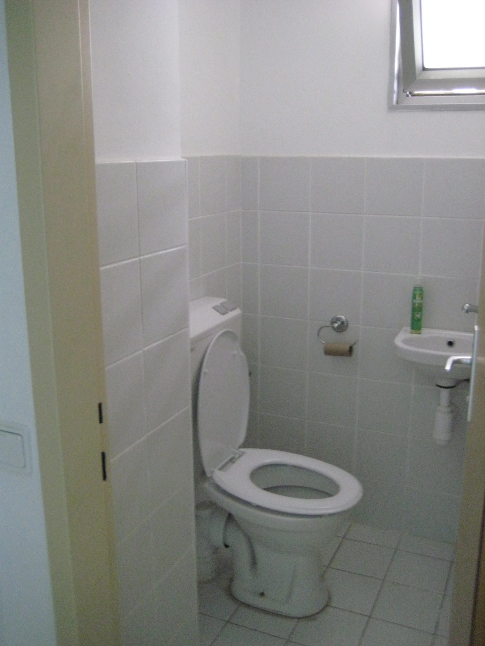 a bathroom with a white toilet and sink