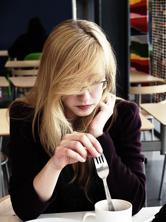 a girl eating at a table in the room