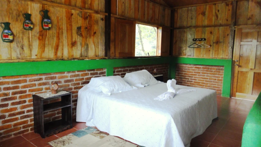 a bed sitting inside of a bedroom on top of a brick floor