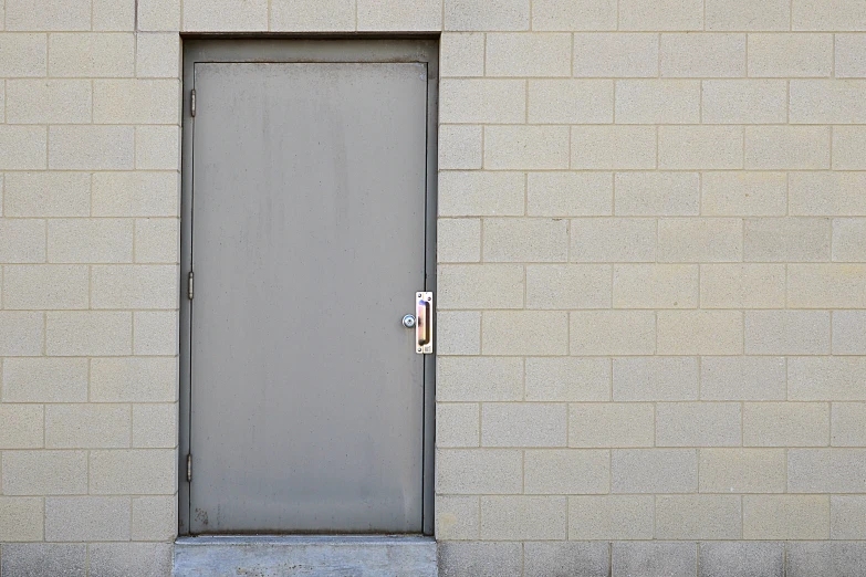 an open door sits on the side of a gray building