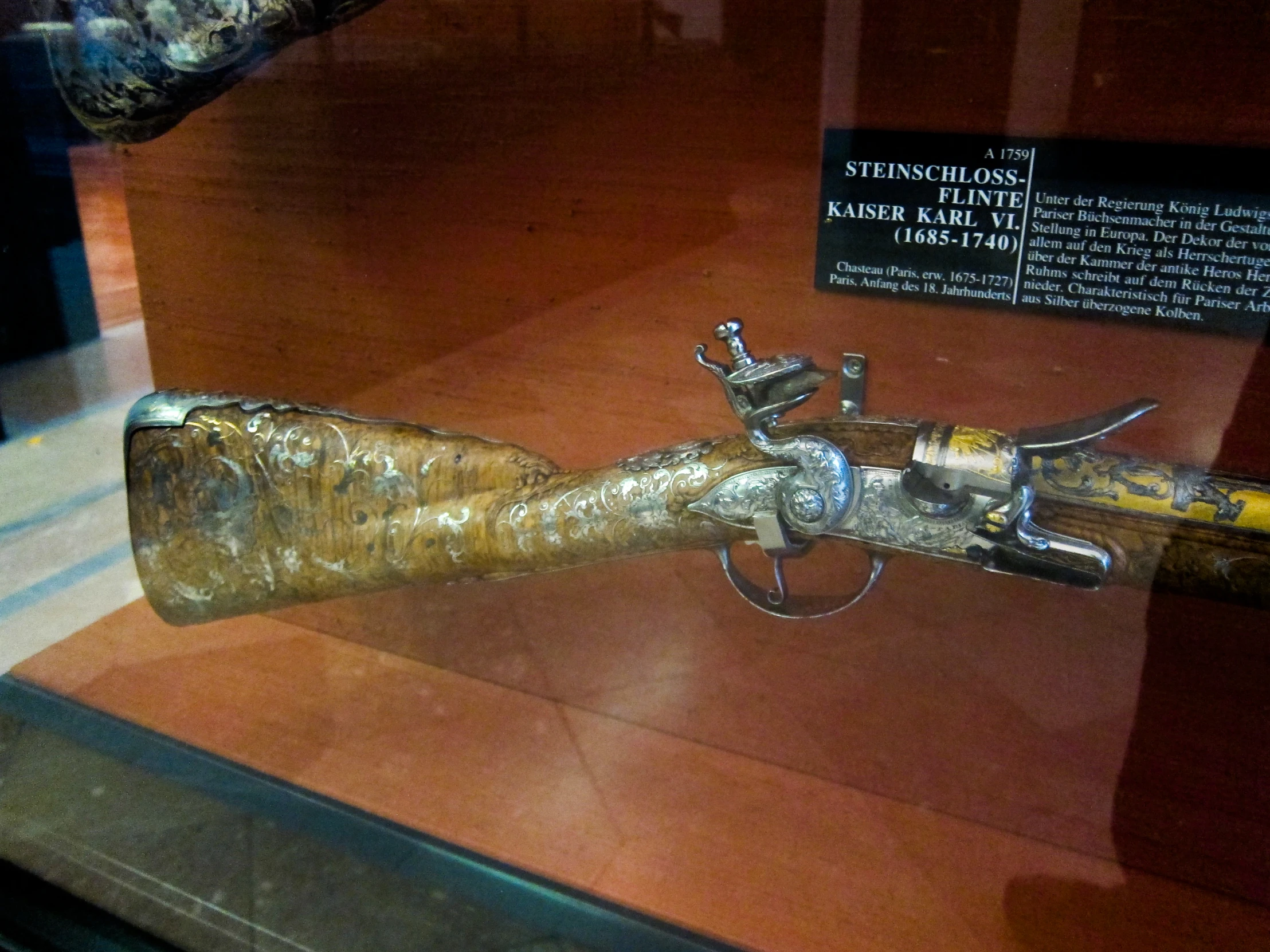 a gun mounted on display with a plaque next to it