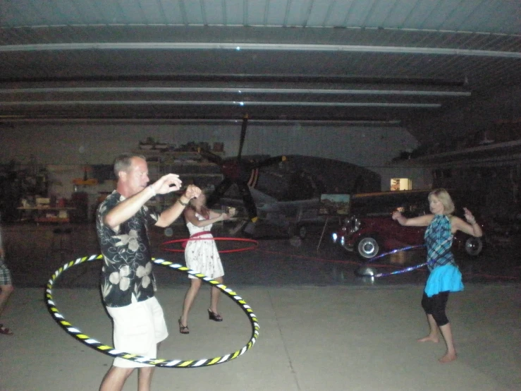 a couple of people that are playing with hula hoop