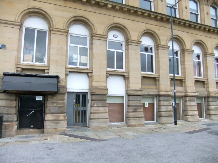 a small street side building with boarded up doors