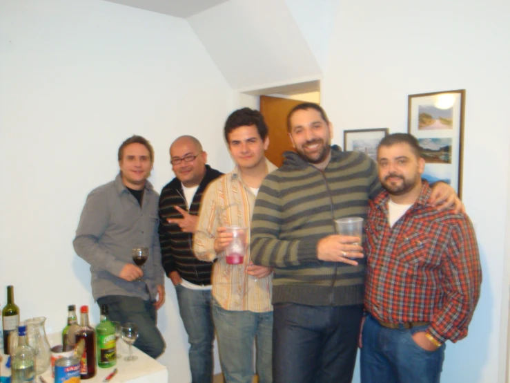 group of men standing in the living room with drinks
