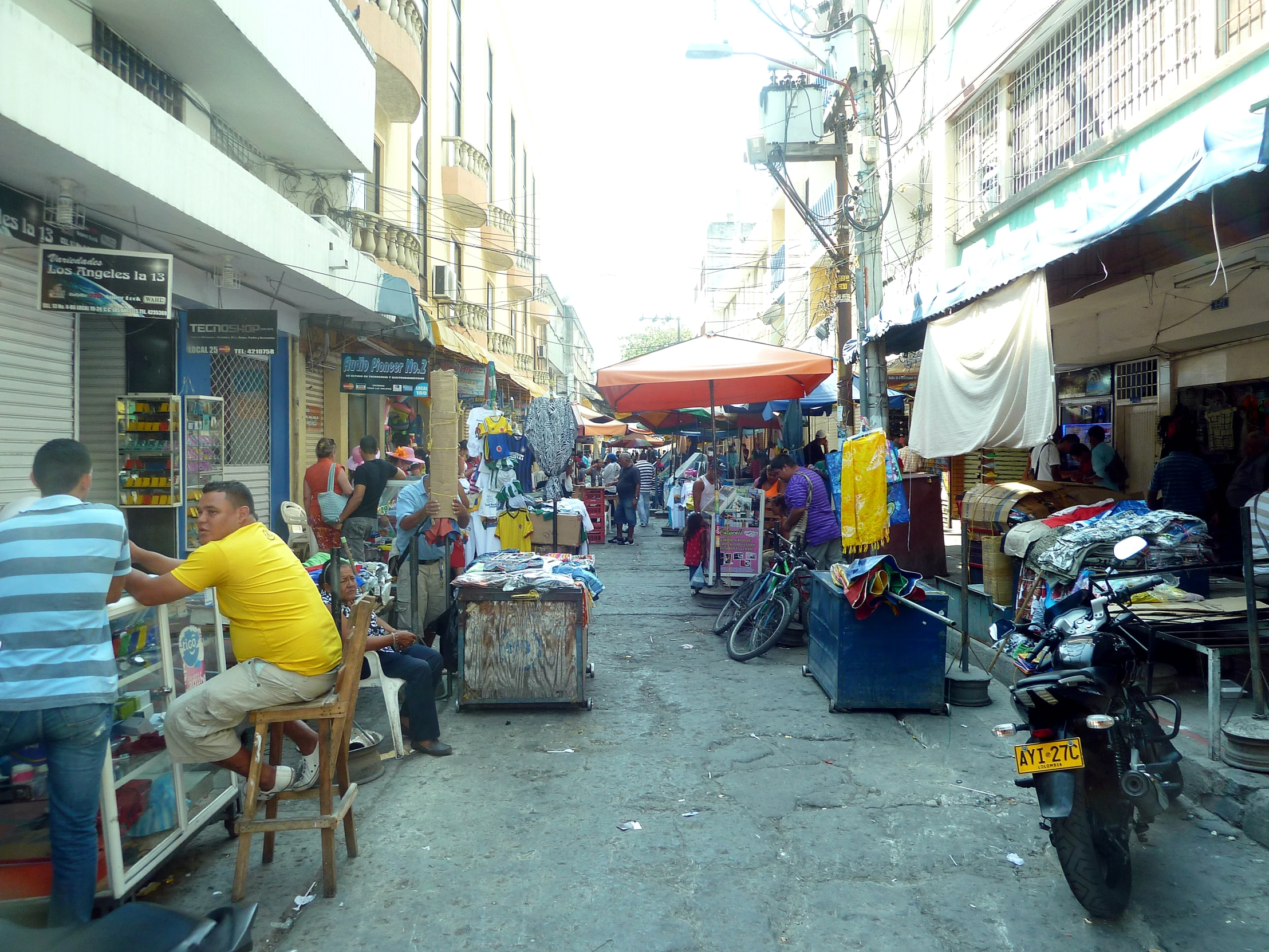 a crowded street is full of people shopping for things