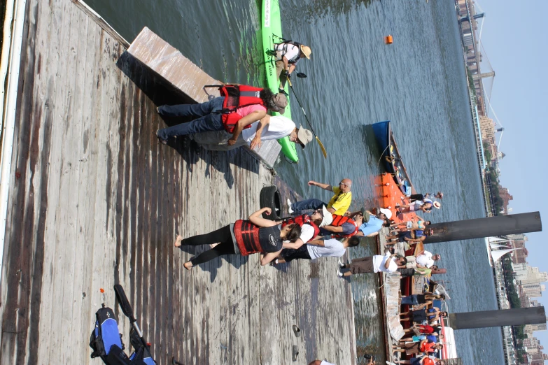 people at a dock near boats and people wearing life jackets