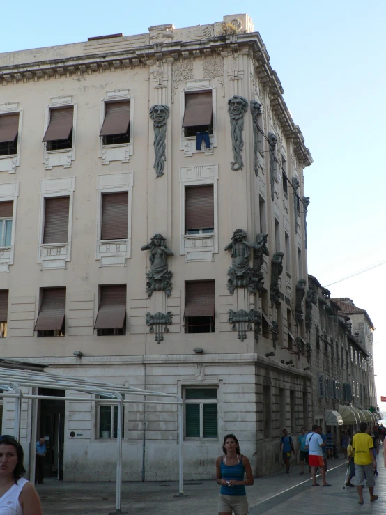 many people are walking in front of a old building