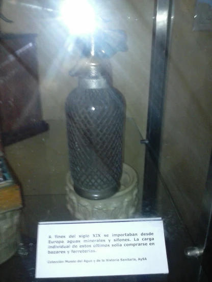 a glass case containing an ornate looking bottle
