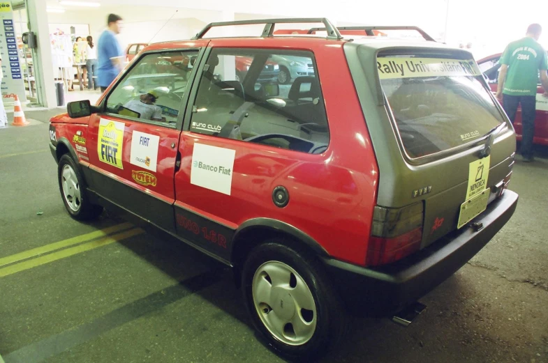 a red car is parked in a parking garage with a yellow stripe on the side