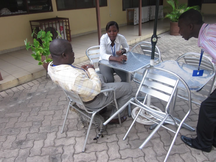 a man sitting at a table with three women standing nearby