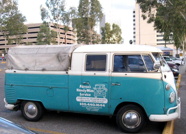 a blue and white vintage vw bus parked in a parking lot