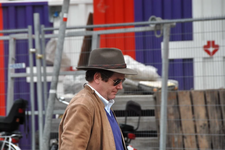 a man wearing a tan jacket and hat