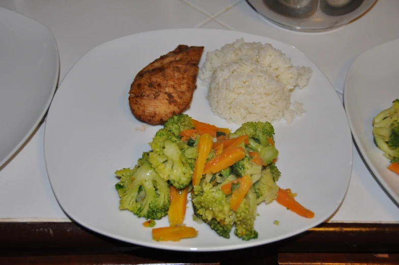 a plate filled with broccoli carrots and chicken