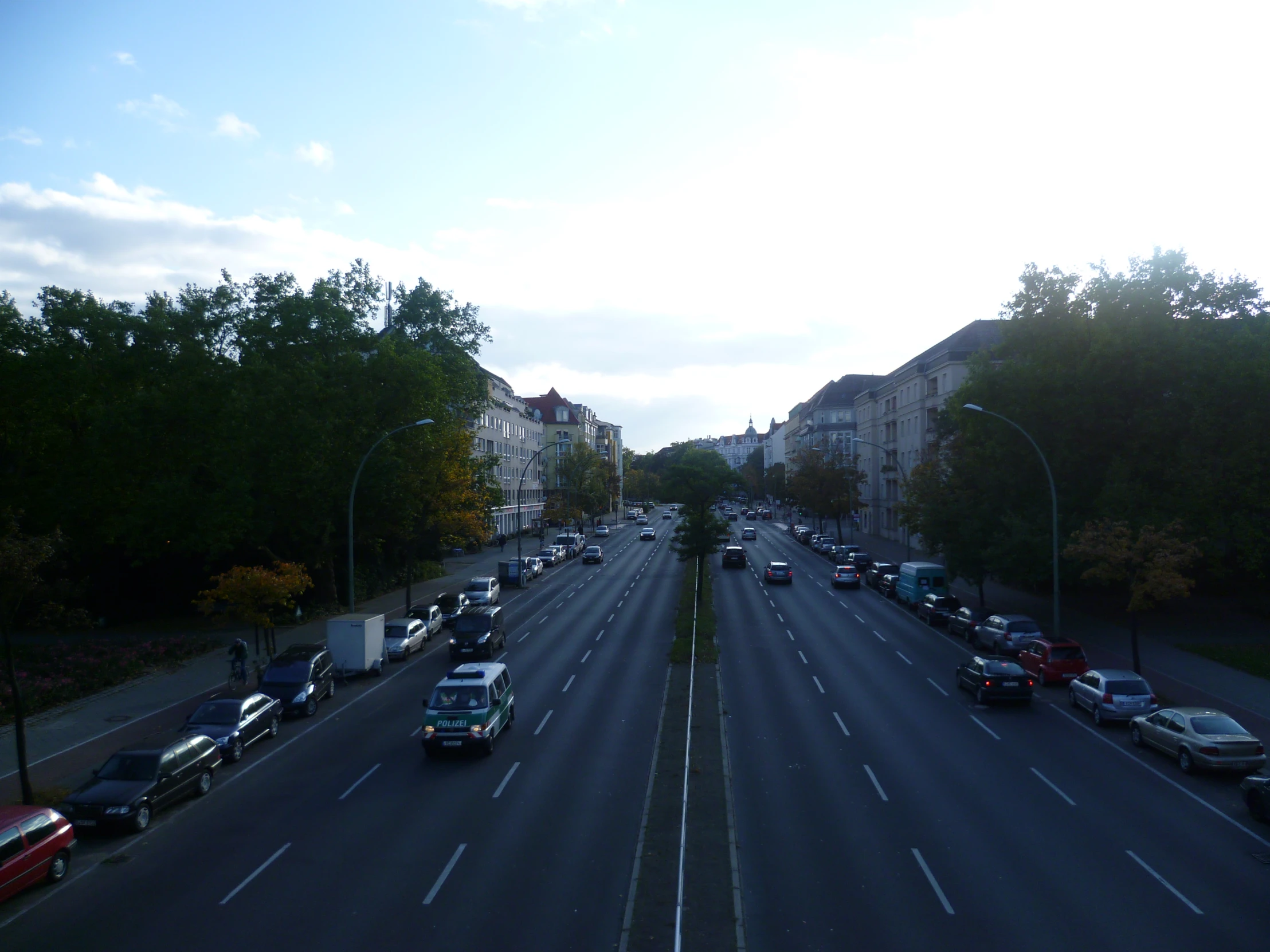 several cars driving down the road and one car is on the left side