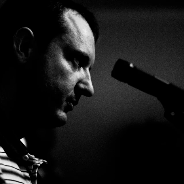 a man talking into a microphone while holding a microphone