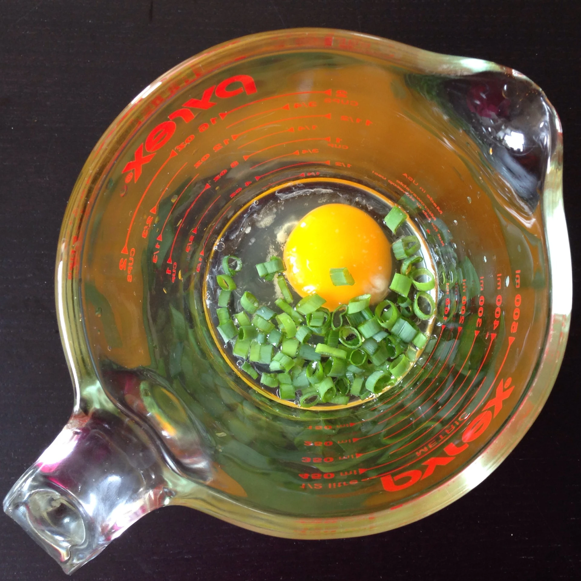 a bowl full of vegetables on a black surface