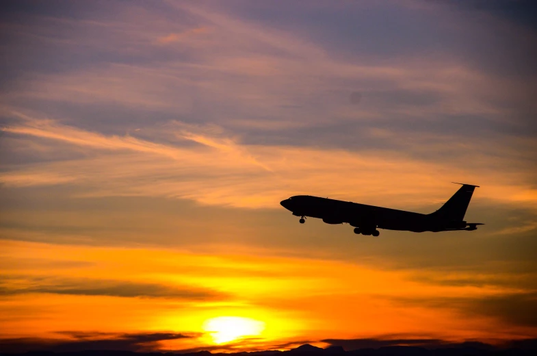 a commercial airliner with the setting sun in the distance