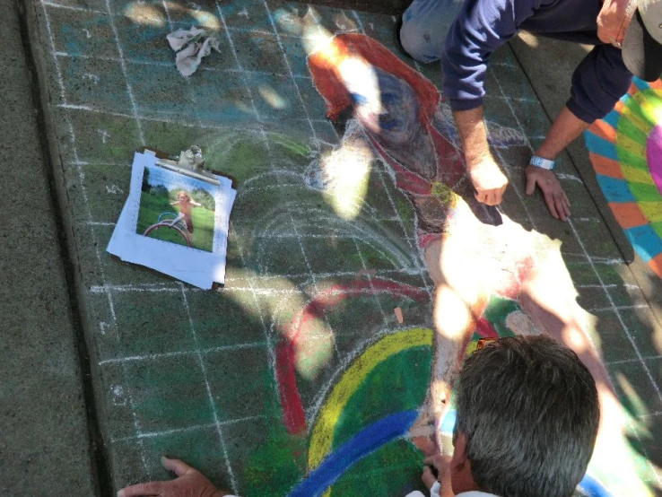 two children playing with chalk and a drawing