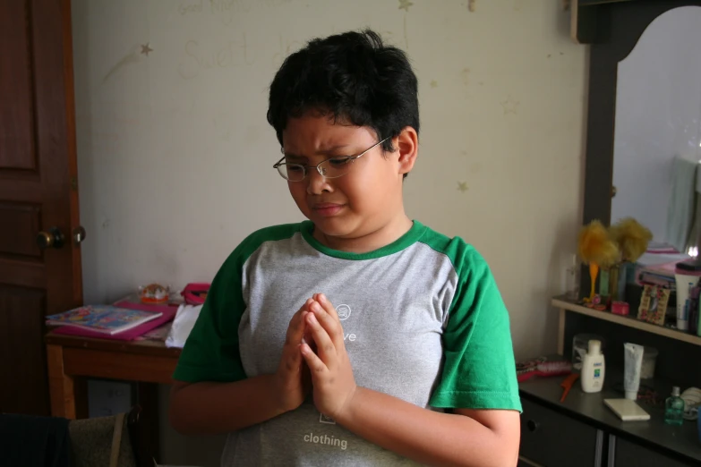 a  wearing glasses standing next to a mirror