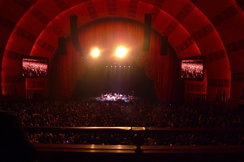 an auditorium with a band on stage lighting up