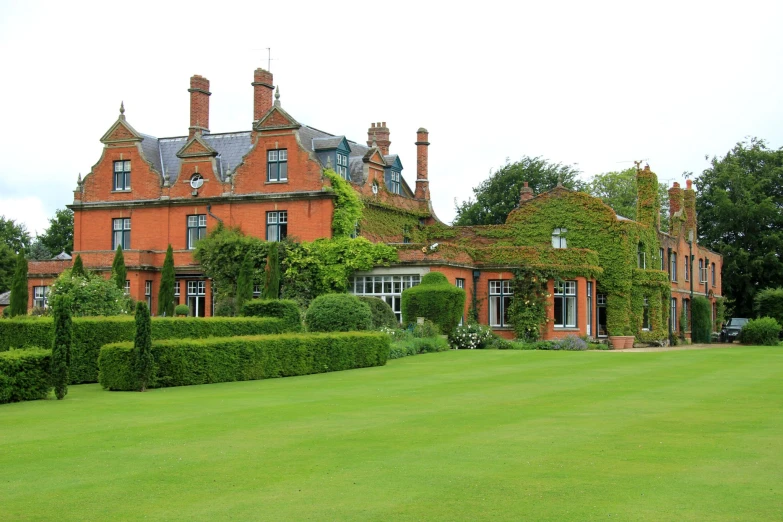 a home with hedges surrounding it and some bushes around it