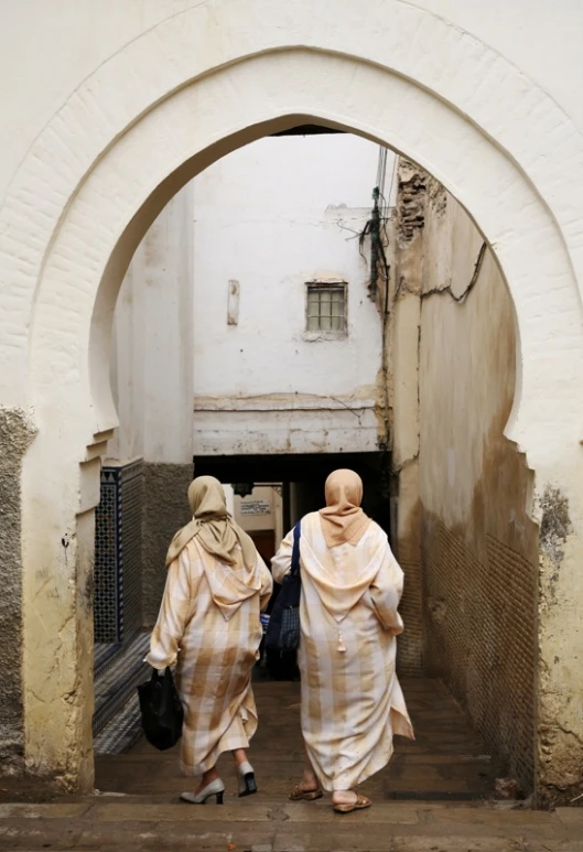 two women are walking out of the tunnel