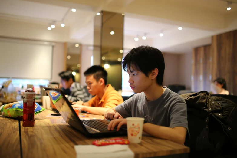a boy using his laptop at the dining table