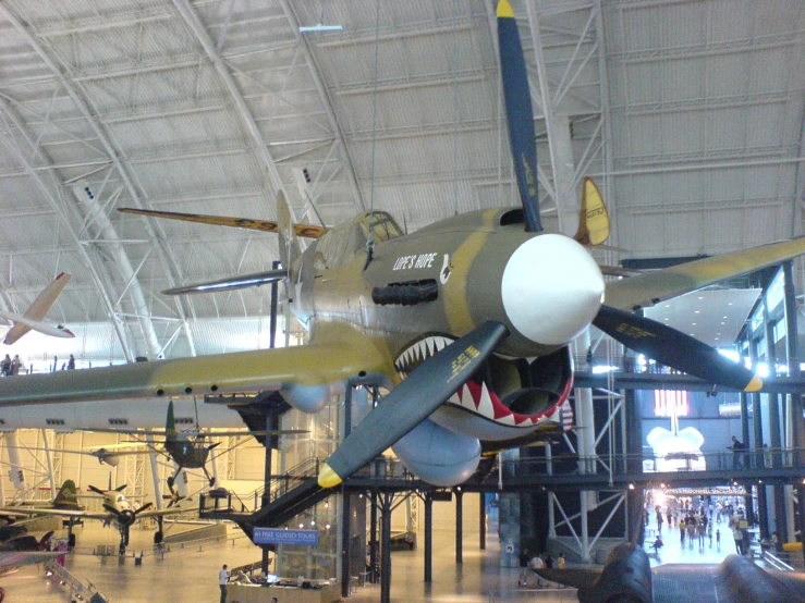 large air plane mounted on the ceiling inside a museum