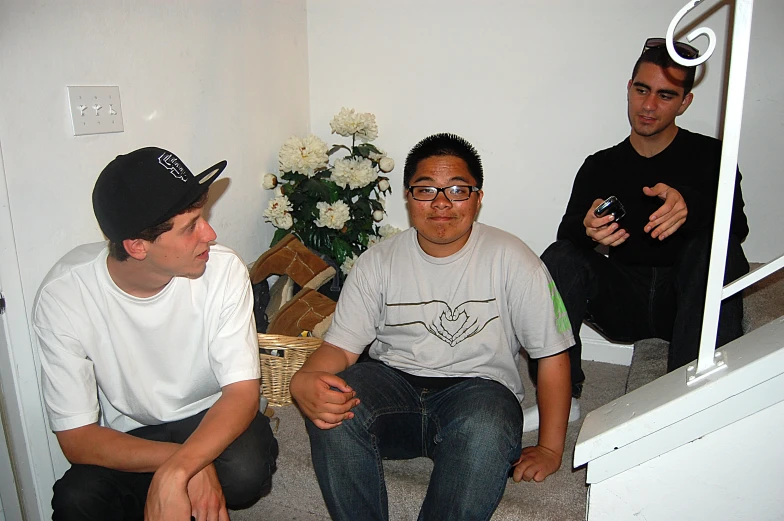 three men sitting on the floor and posing for a picture