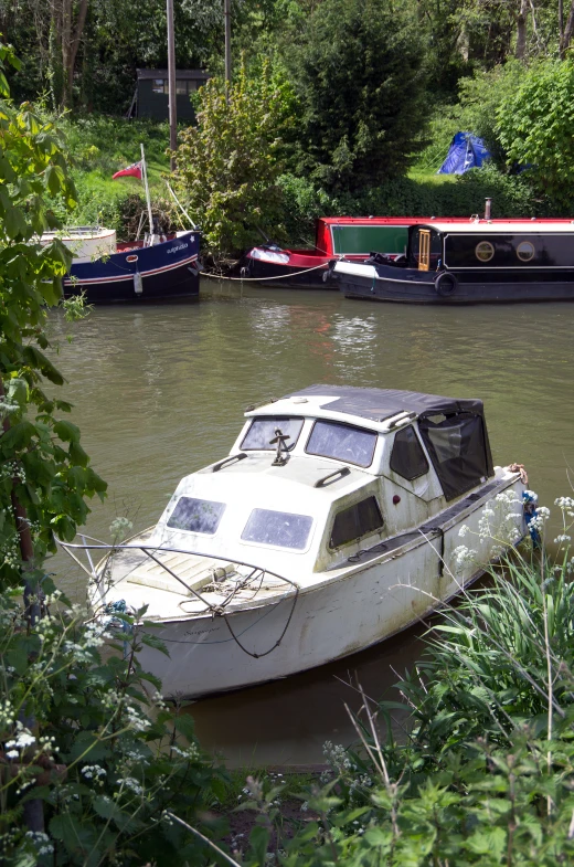 two boats floating on top of a river near a forest