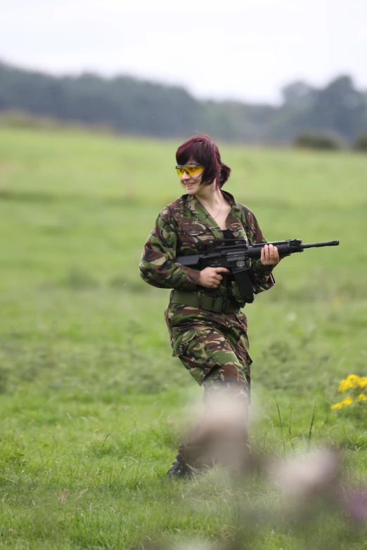 a woman with a gun in a field