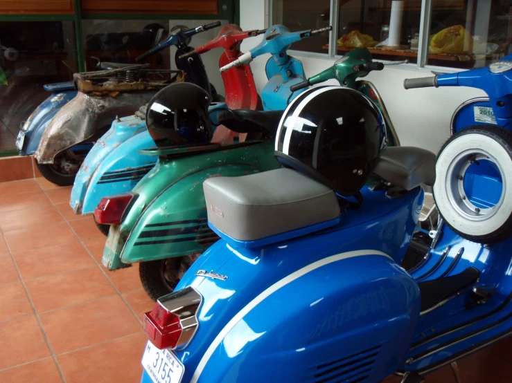 a row of motor bikes lined up on the side of a building