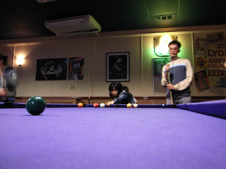 a woman and a man playing pool in a public room