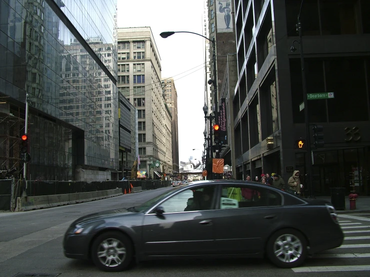 car driving down a street near tall buildings