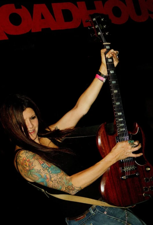 a woman with tattoos playing the guitar