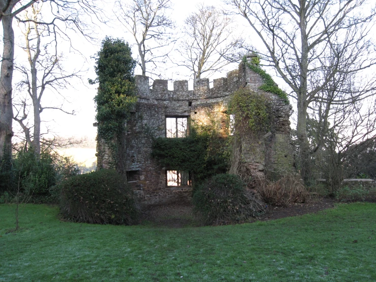 the ruins of an old, stone building with ivy on them