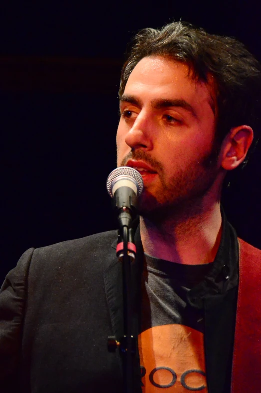 a man standing at a microphone in front of a microphone