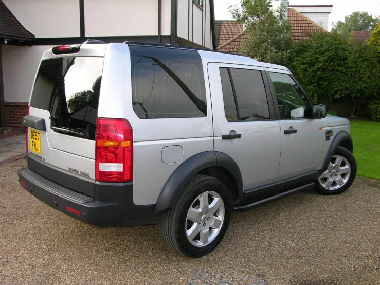 a gray land rover is parked in front of a building